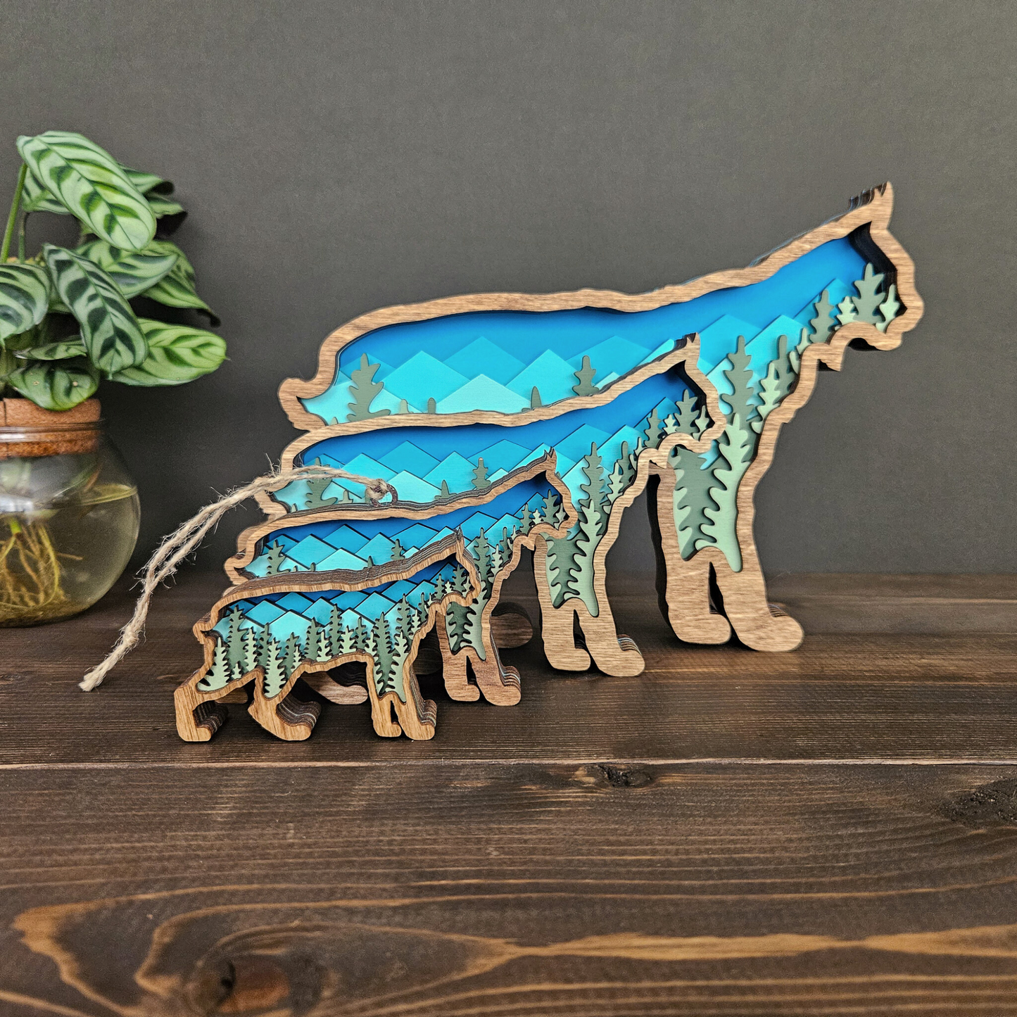 Set of four sizes and designs of Bobcat or Lynx art and decor pieces standing in front of each other in this order: Mini, Ornament, Small, Medium