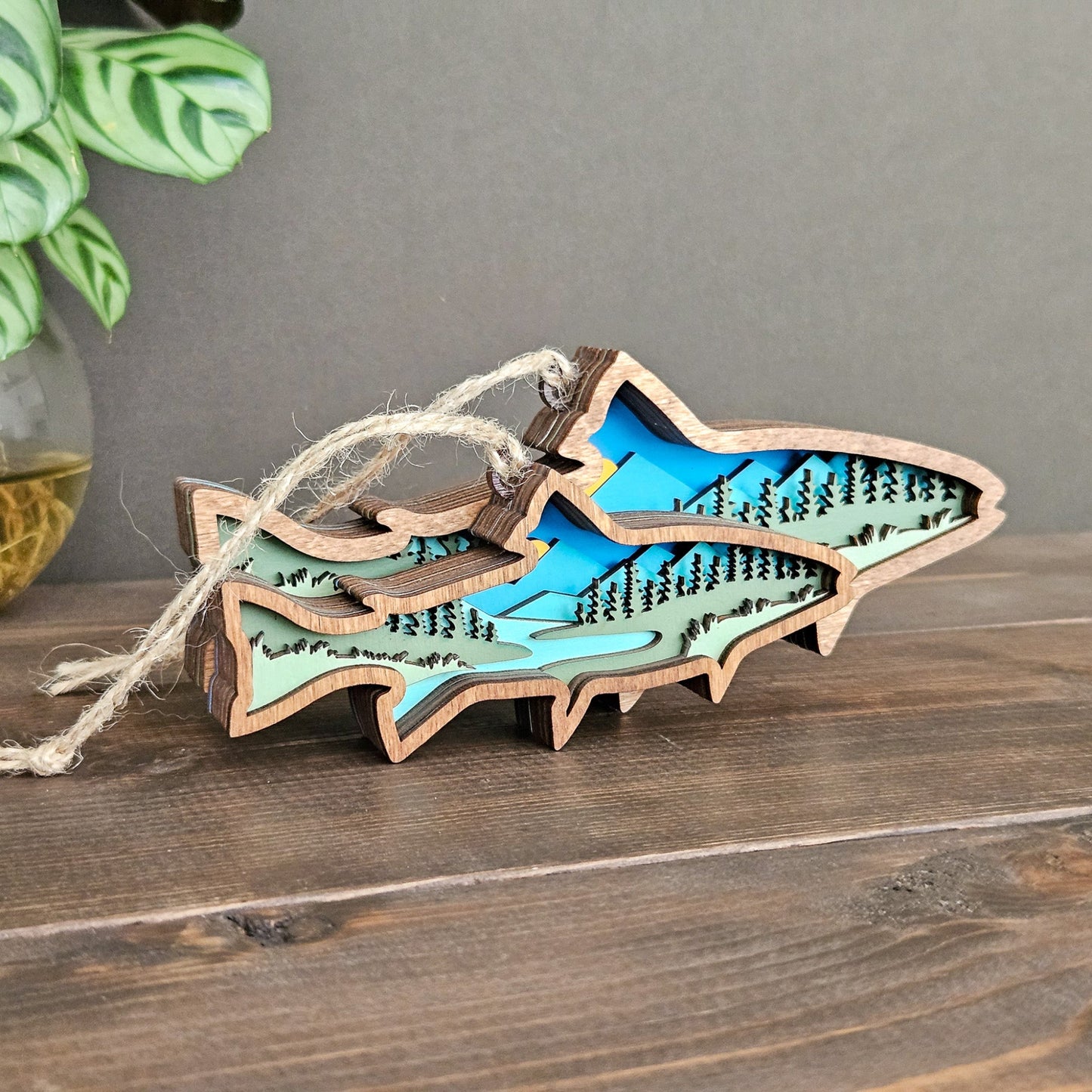 Wooden fish-shaped ornament with cut-out details on a wooden surface