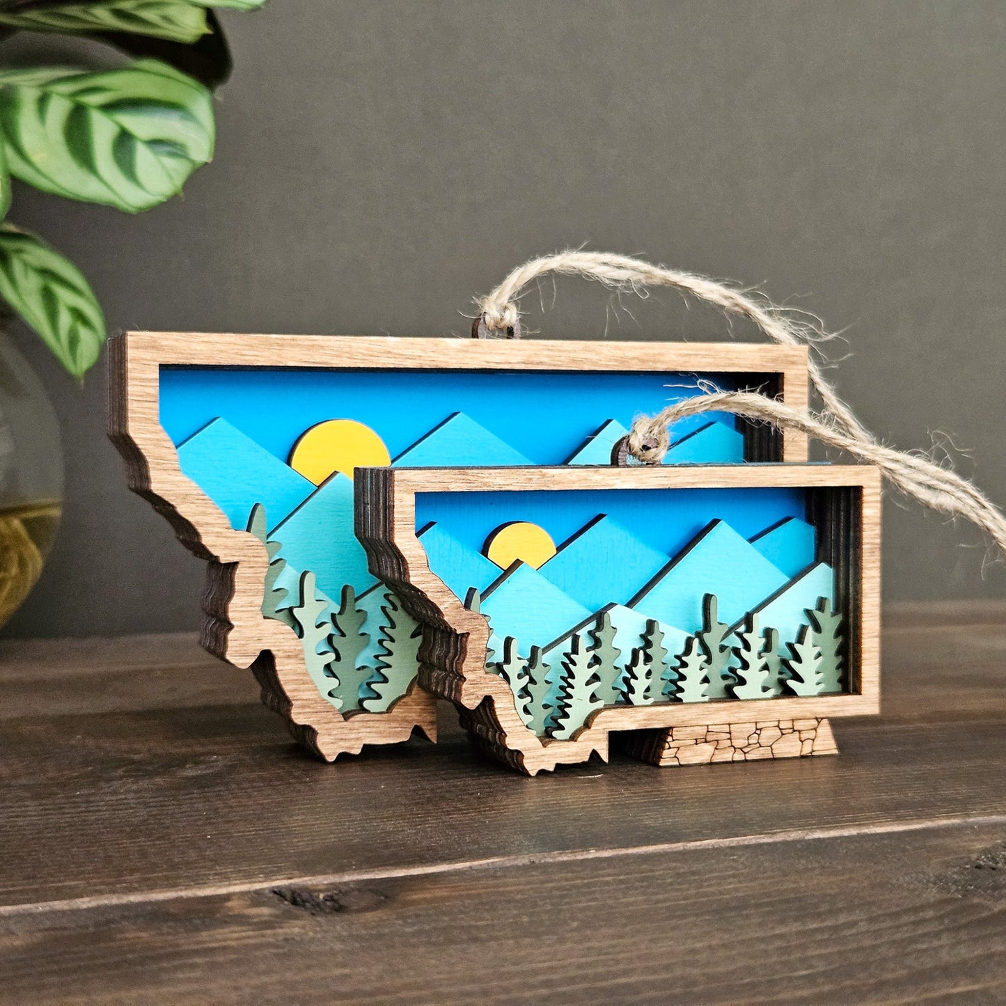 Wooden ornament with mountain and sun design on a wooden surface
