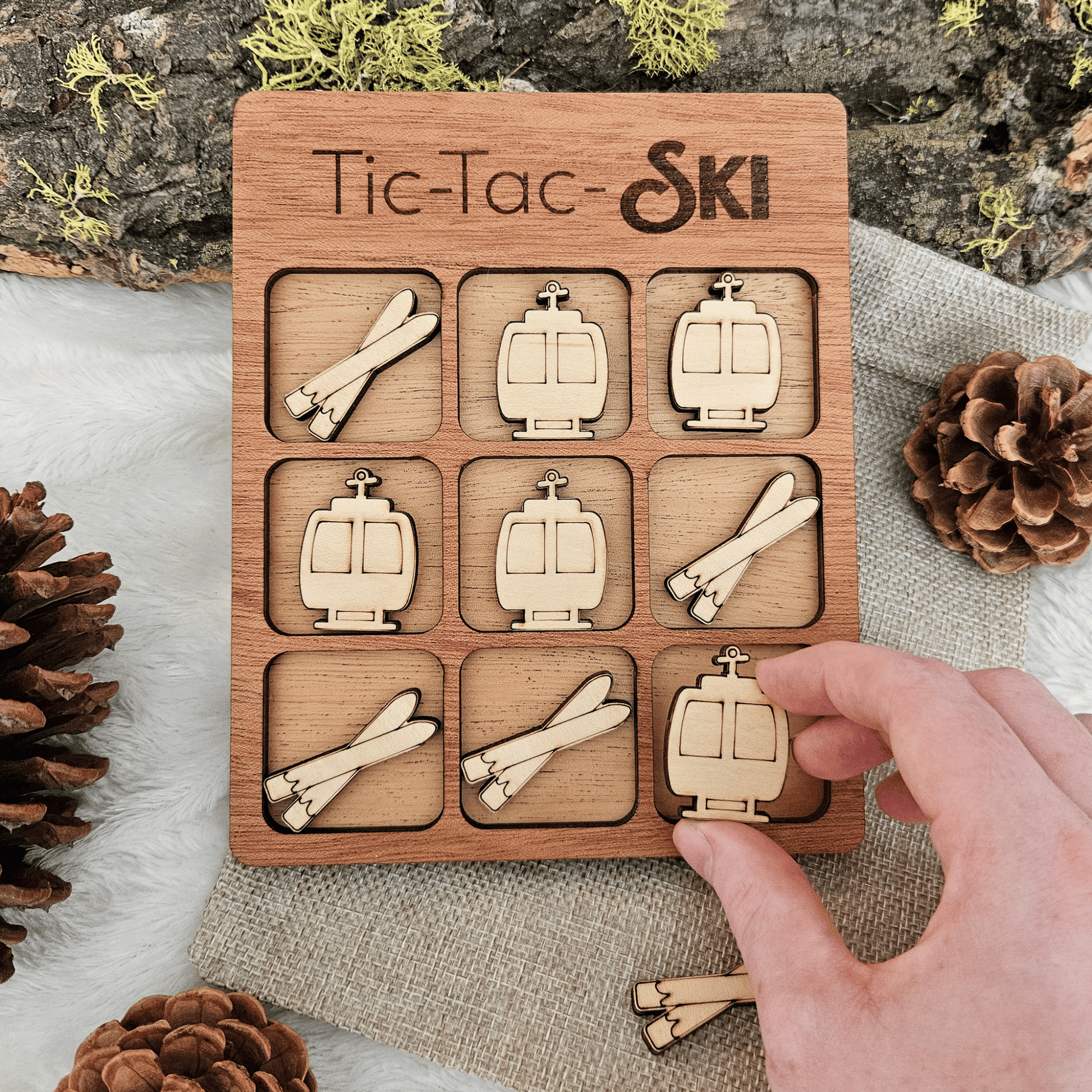 Wooden Tic-Tac-Toe game with ski-themed pieces on a rustic background