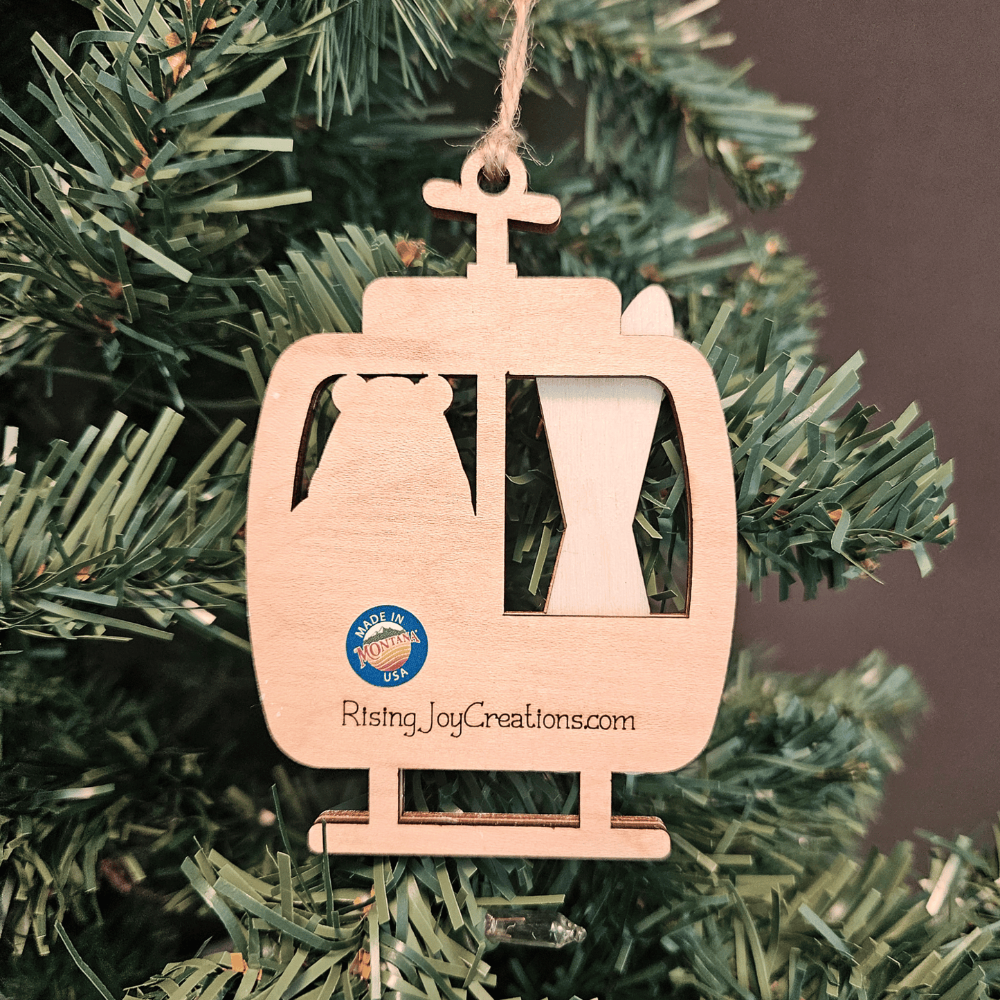 Wooden ski lift ornament with 'Made in Montana USA' logo on a Christmas tree.