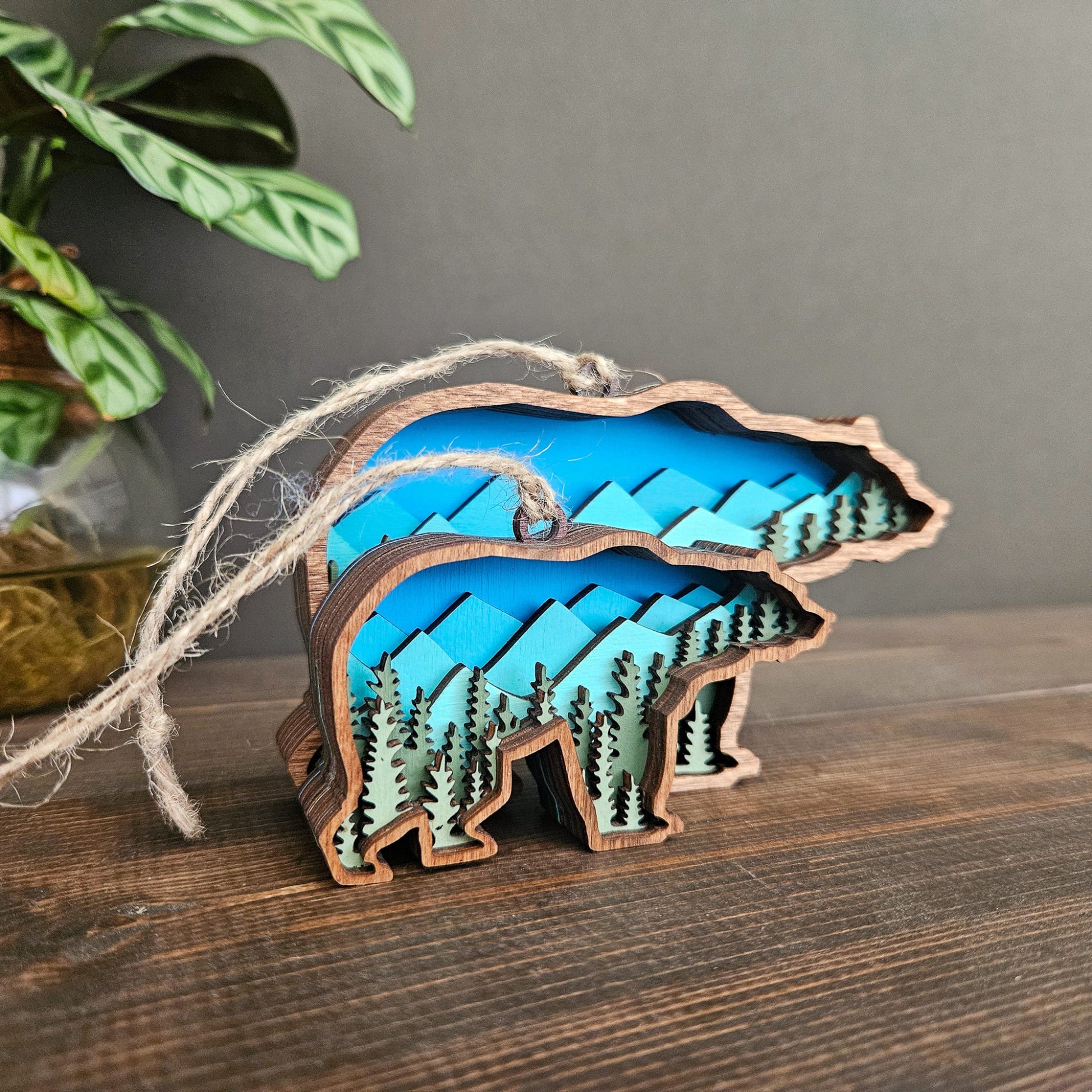 Wooden bear ornament with blue and green design on a wooden surface