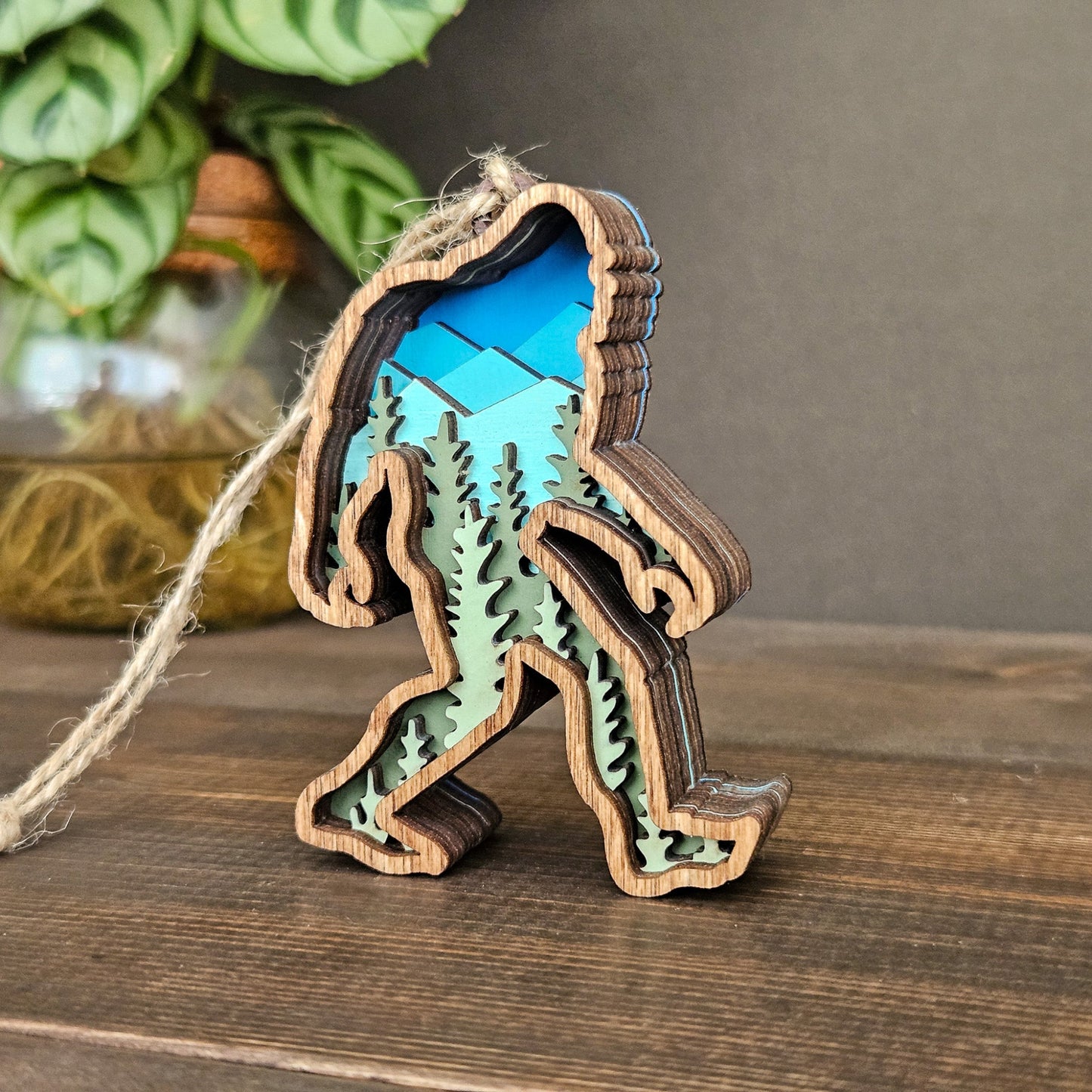 Wooden bigfoot ornament with blue interior on a wooden surface