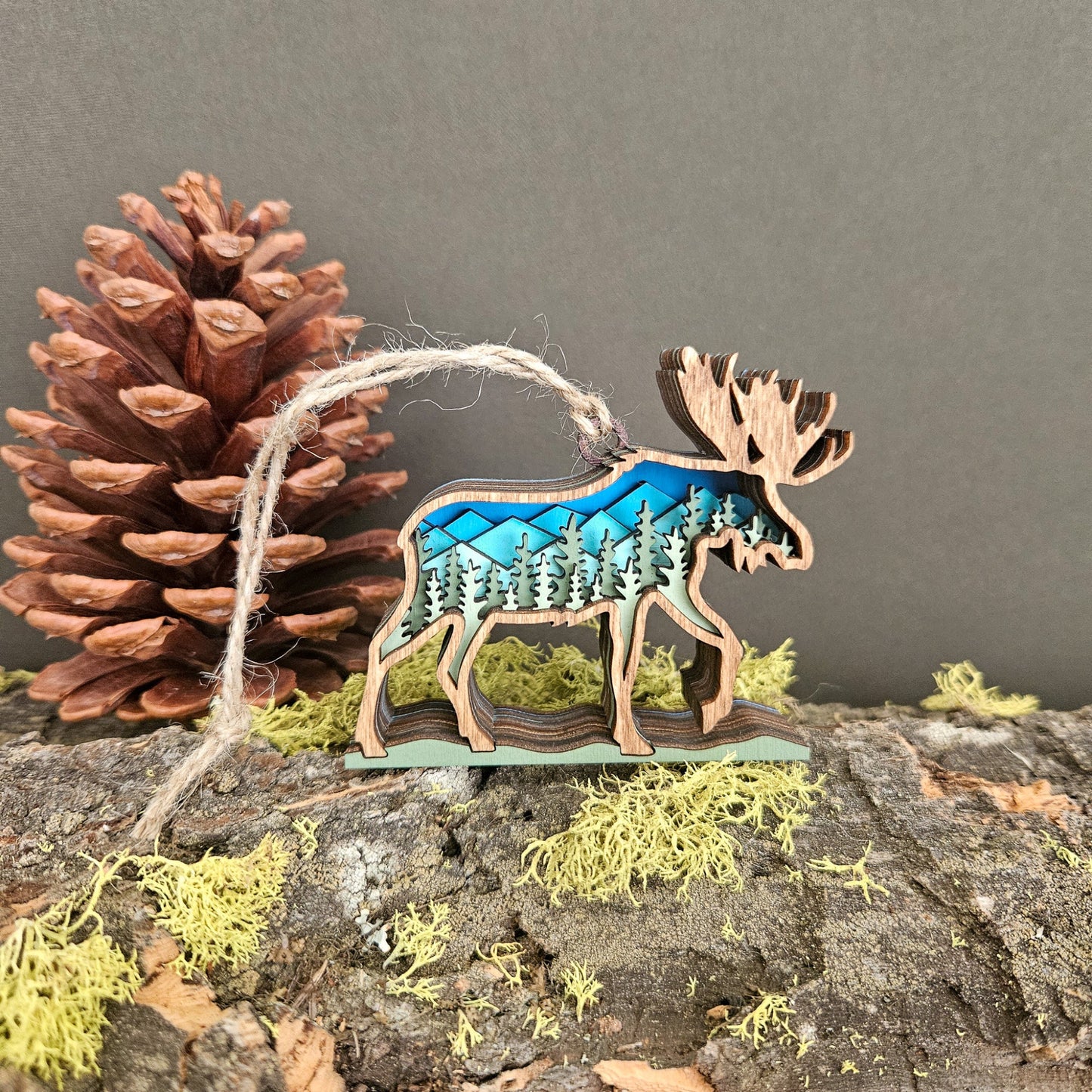 Wooden moose ornament with blue design on a natural background