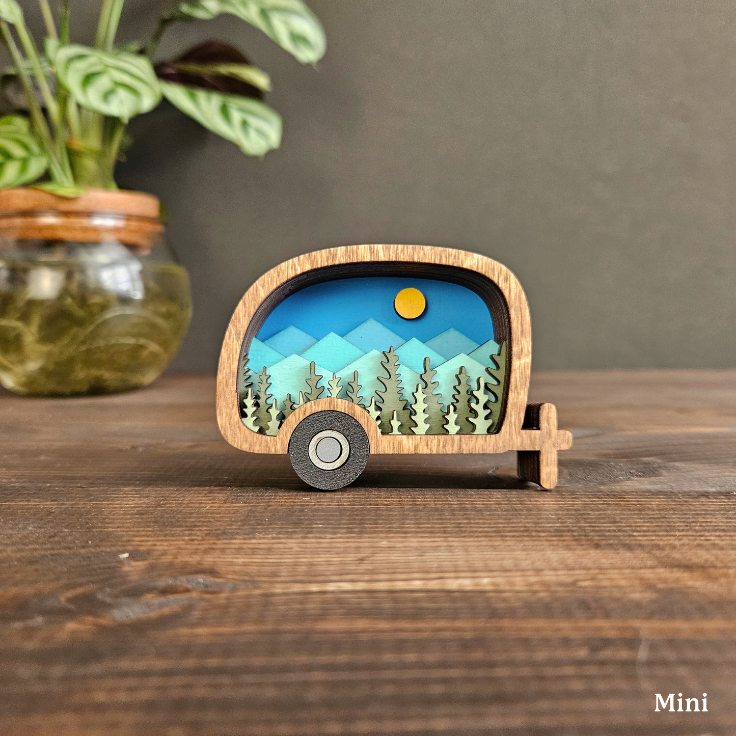 Wooden model of a camper with a scenic design on a wooden surface, 