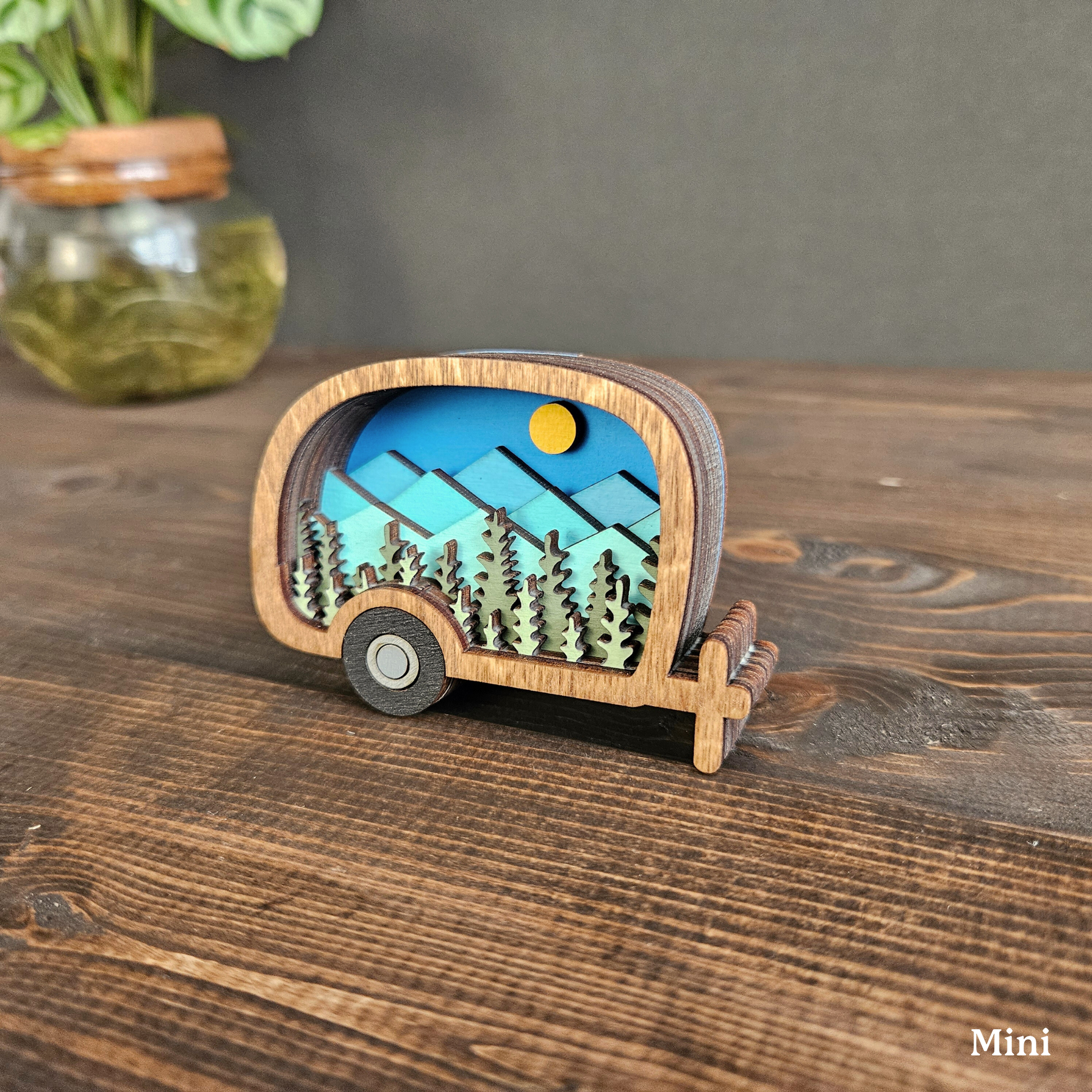 Wood retro camper with a scenic design on a wooden surface