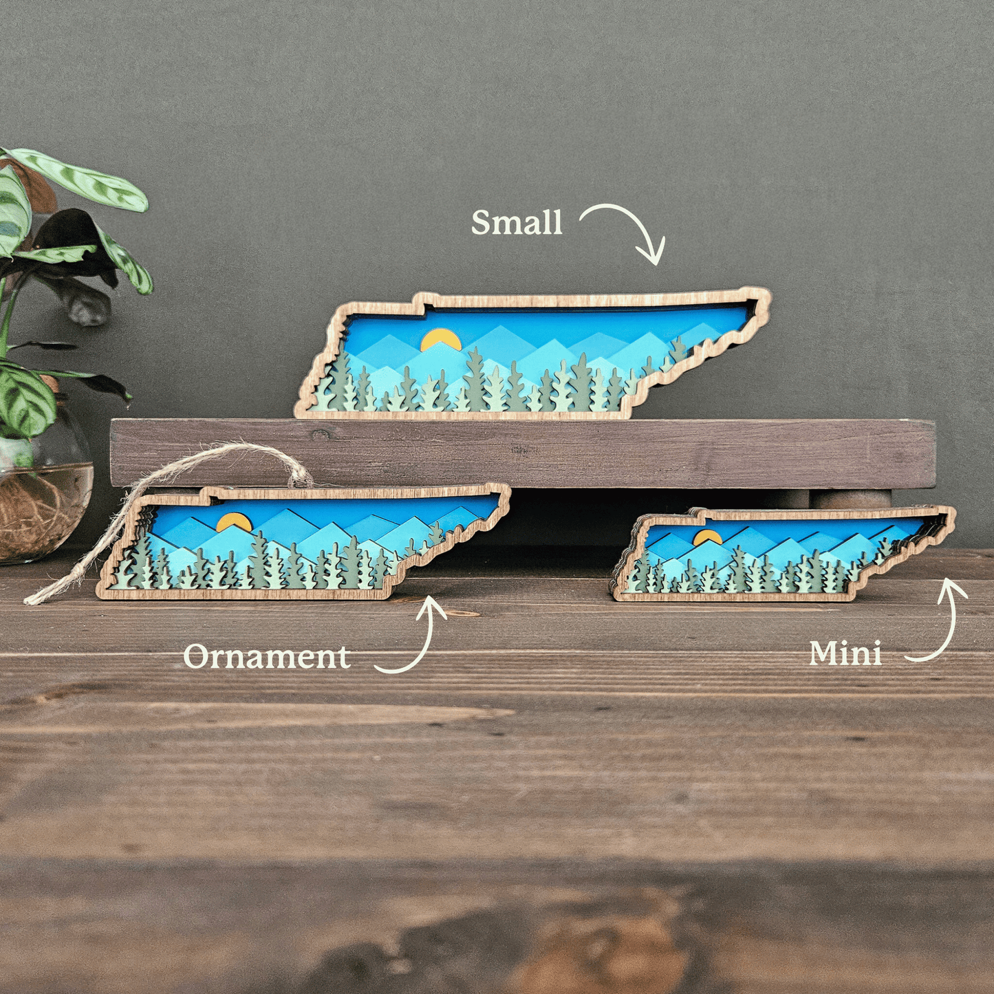Size comparison photo labeled mini, ornament, and small layered Tennessee mountain designs — handcrafted wood state art by Rising Joy Creations.