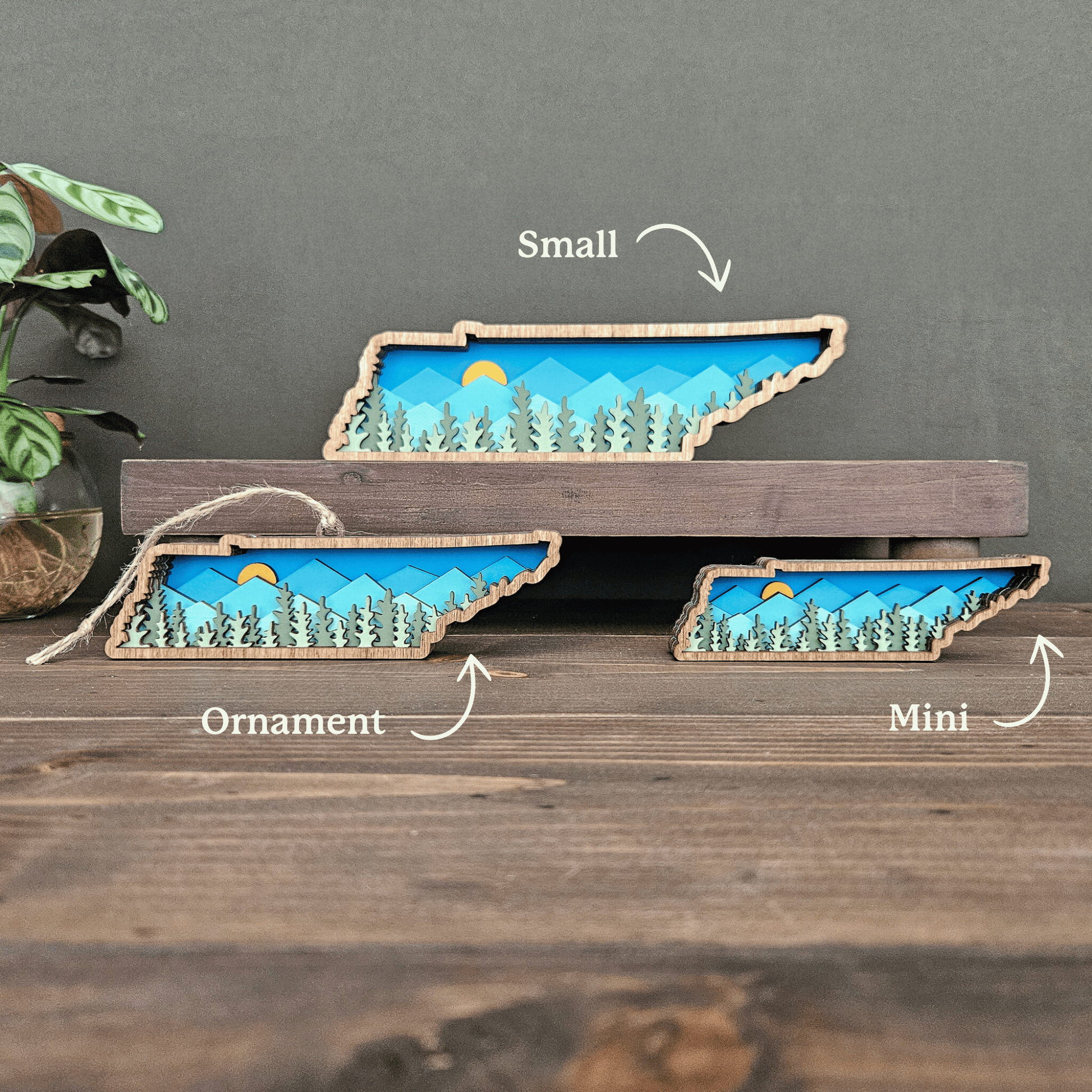 Size comparison photo labeled mini, ornament, and small layered Tennessee mountain designs — handcrafted wood state art by Rising Joy Creations.