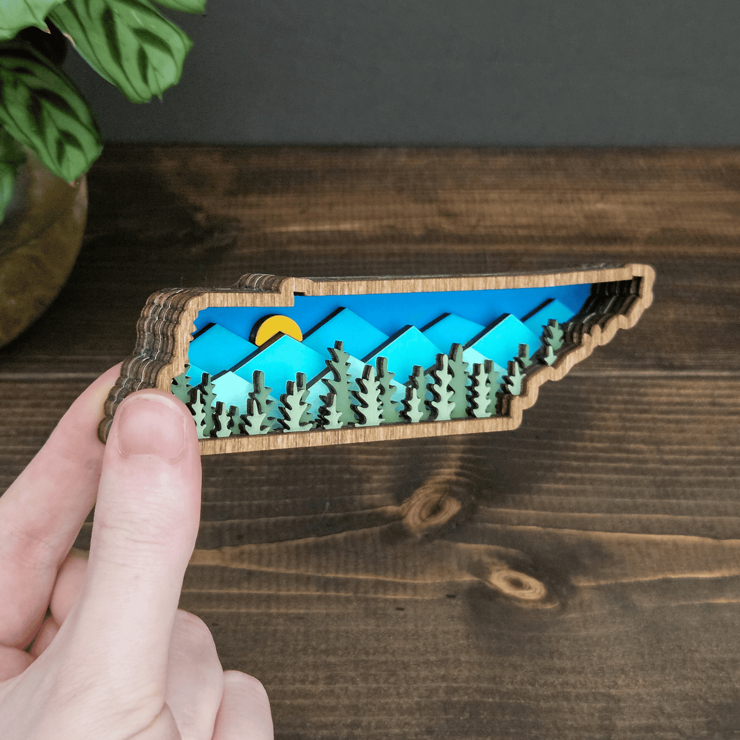 Side angle of mini Tennessee mountain magnet showing layered wood depth and colorful mountain scene — handmade rustic state decor.