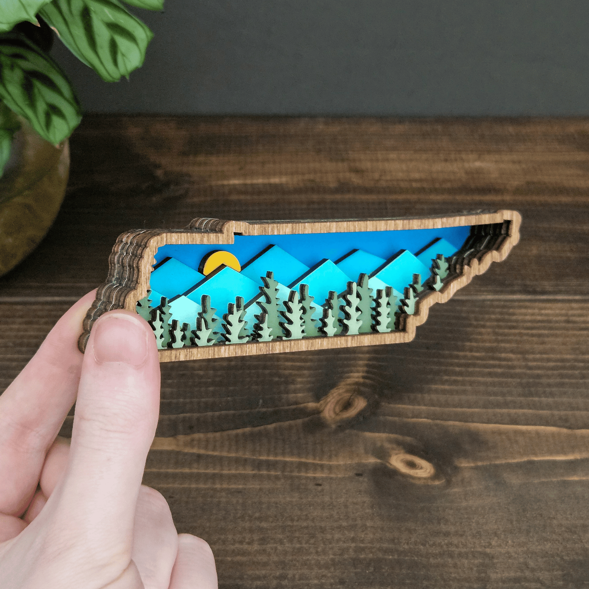 Side angle of mini Tennessee mountain magnet showing layered wood depth and colorful mountain scene — handmade rustic state decor.