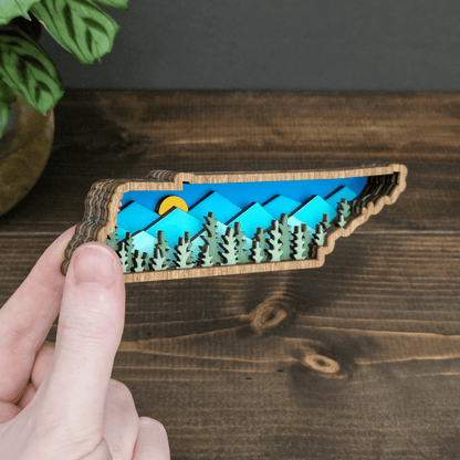 Side angle of mini Tennessee mountain magnet showing layered wood depth and colorful mountain scene — handmade rustic state decor.