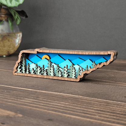 Mini Tennessee layered wood magnet displayed on wooden surface — handcrafted mountain scene decor piece.