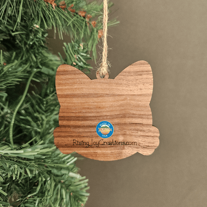 Wooden personalized cat ornament with engraved name Bella hanging from jute twine on a Christmas tree