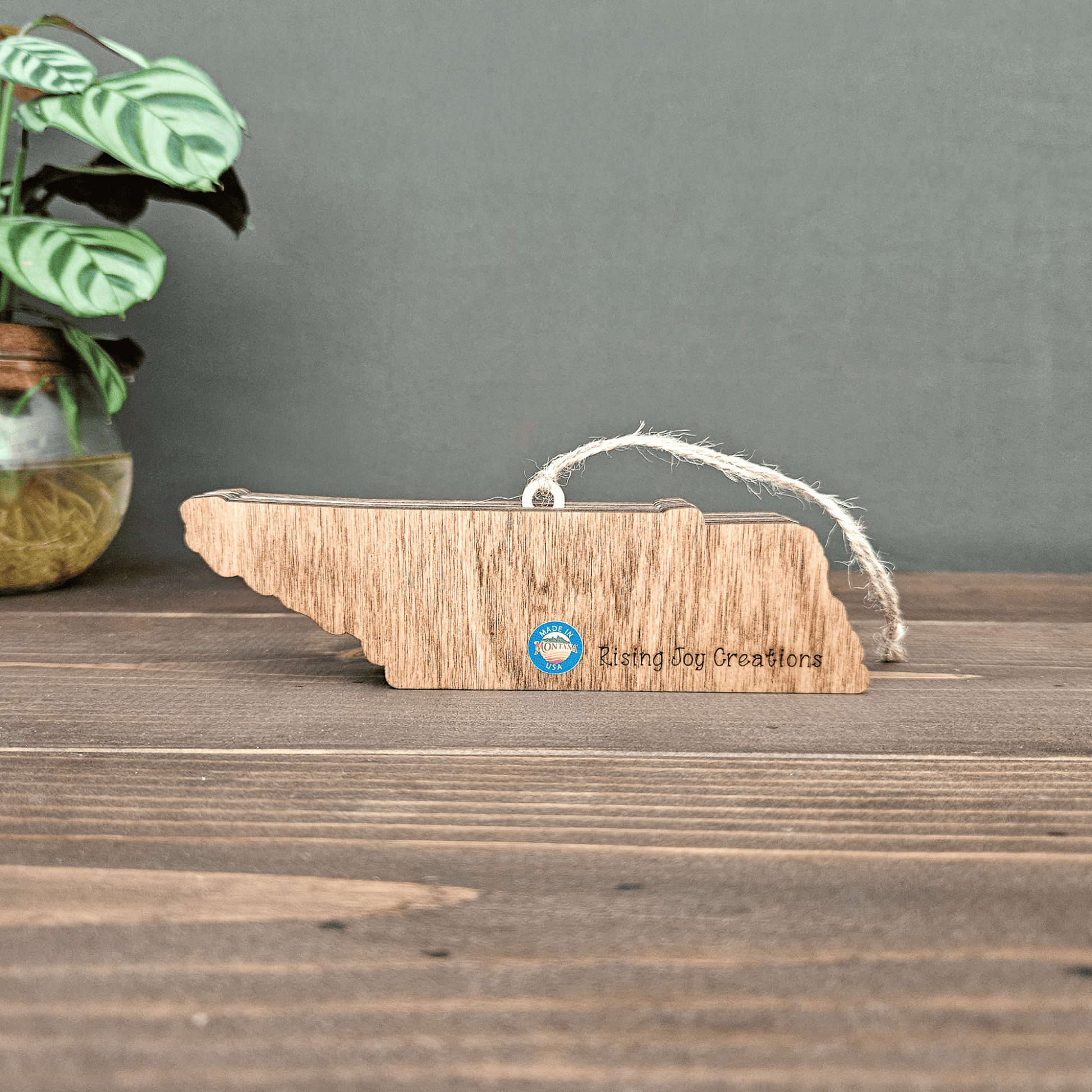 Back view of layered Tennessee ornament engraved with Rising Joy Creations logo and Made in Montana sticker.