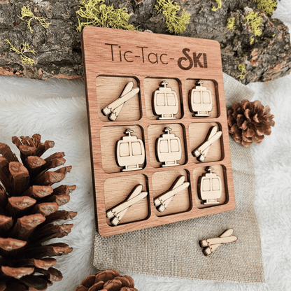 Wooden Tic-Tac-Toe game set with ski-themed pieces on a natural background
